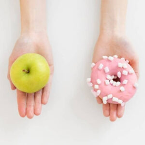 Close up hands holding doughnut and apple